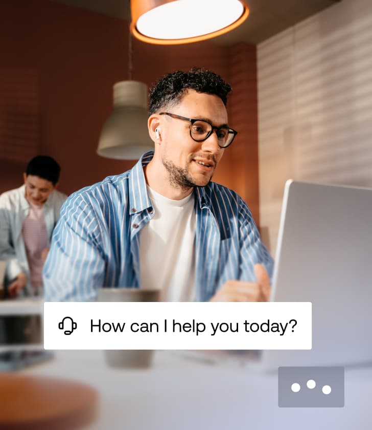 Support agent with headset working at a laptop with a overlay asking How can I help you today